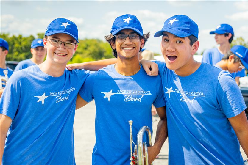 Three boys in band t-shirts smile